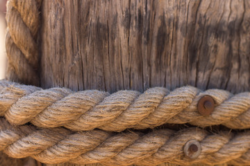 Fototapeta na wymiar rope around wood pillar nautical ship object, wooden background texture