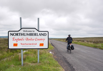 Male cyclist entering Northumberland on the Coast to Coast trail, UK