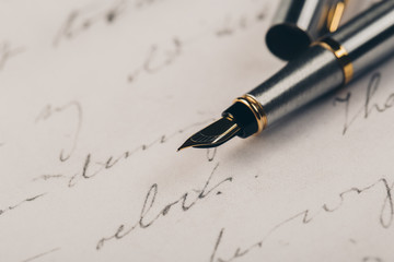 Fountain pen on an ancient handwritten letter. Old story. Retro style.