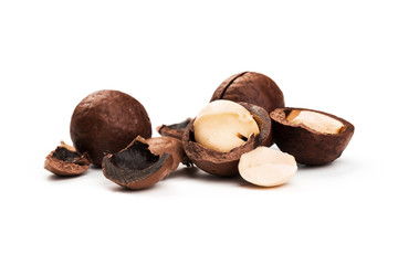 Raw not peeled whole macadamia nuts with shelled kernels isolated on white. Macro view. Healthy food. Protein source.