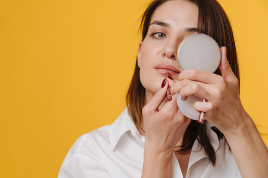 Attractive Woman In A White Dress Shirt Holding Hand Mirror, Applying Lipstick