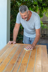 A man working on recycling wood table in the garden, carpenter work.