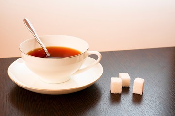 sugar with tea in a white cup