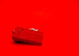 Gift for Valentine's Day. Christmas present. Gift wrapping tied with ribbon on a red background.