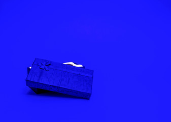 Fototapeta premium Gift for Valentine's Day. Christmas present. Gift wrap tied with ribbon on a blue background.