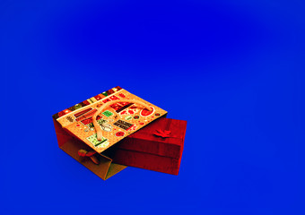 Gift for Valentine's Day. Christmas present. Gift wrap tied with ribbon in a paper bag on a blue background.