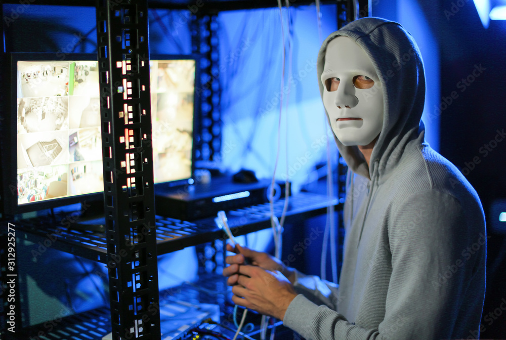 Poster professional hacker near computer in dark room