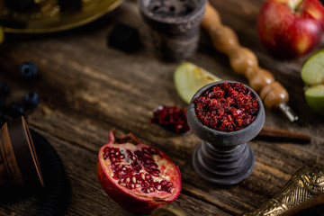 Stone hookah head on old rustic table with fruit flavoured tobacco