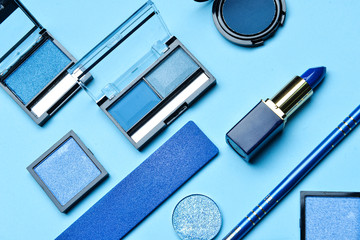 Set of blue makeup cosmetics on color background