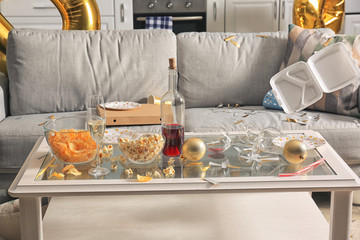 Table with terrible mess in room after New Year party