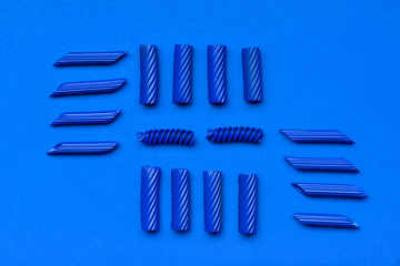Raw painted pasta on blue background