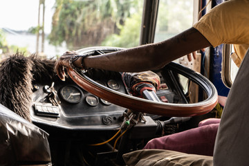 A driver drives a bus in Asia. Close-up of the steering wheel and hands.