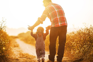Child pilot aviator with airplane dreams of traveling in summer in nature at sunset，Happy kid...