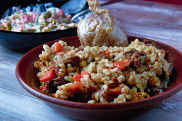 Uzbek national plov dish on a clay plate closeup.