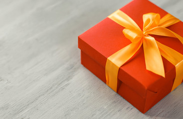 red box tied with a gold ribbon. the ribbon is tied on a box in the form of a beautiful bow. holiday gift concept