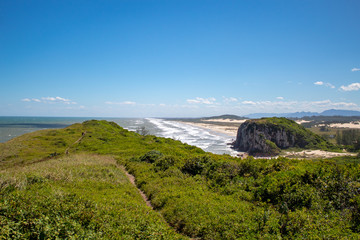 Falésia, e vegetação típica da praia da Guarita da cidade de Torres em dia de sol, praia tropical, Brasil