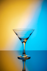 Martini glass on a colored background with reflection