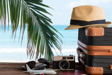 Summer travel and plan with vintage suitcase luggage and old camera in the sand beach. Travel in the holiday trips, airplane.  blue sky background. Summer and Travel Concept