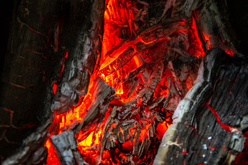 Hot burning coals in the fireplace. The texture of a burning tree.