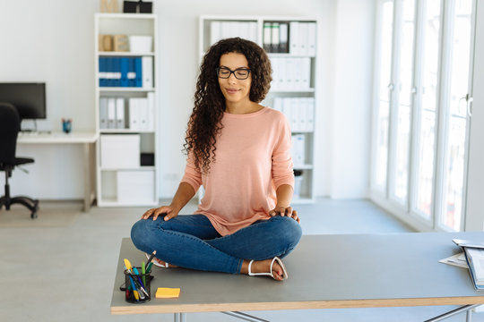 Young businesswoman sitting meditating