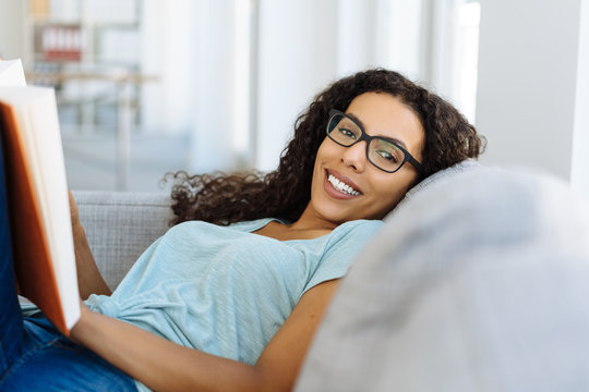 Happy friendly young woman relaxing on a sofa