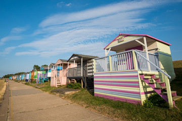 Fototapeta na wymiar Colourful wooden beach huts facing the ocean at Whitstable coast, Kent district England.