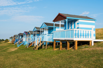 Colourful wooden beach huts facing the ocean at Whitstable coast,  Kent district England.