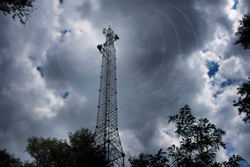 Cellular mobile communications tower, against the background of the night sky.