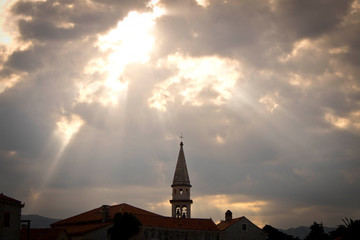 Obraz premium Rays sun falling through clouds on the old city. Selective focus.