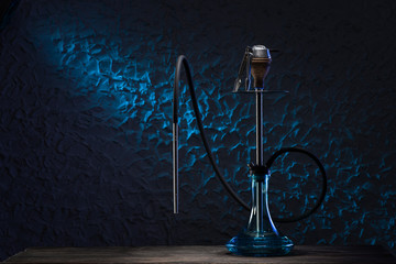 Preparing a hookah for using. Hookah on blue background. East smoking hookah with neon light. Trendy shisha for relax - obrazy, fototapety, plakaty