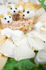 Holiday Christmas salad mouse 2020 New Year cheese piece shape on a white plate. Boiled eggs with cheese look like white mice (rats), horizontal, close up
