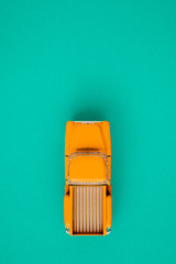 Yellow retro car pickup on a green background. Top view with copy space. Flat lay