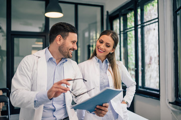 Portrait of a happy doctor talking to a colleague about his doctoral dissertation.