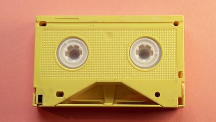 Fototapeta premium Yellow video tape on orange background, VHS, 90s concept, videotape, cassette