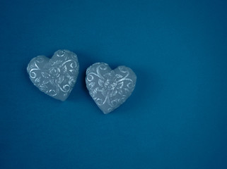 Couple of silver handmade soap in the shape of hearts on a blue background top view with copy space. Authentic romantic Valentine's day gift, symbol of love and passion.