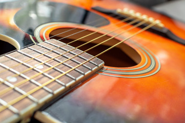 Bridge, soundhole and strings of a wooden classical guitar with shallow depth of field, close up