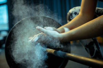 Caucasian teenage girl practicing in weightlifting in gym. Female sportive model preapring for...