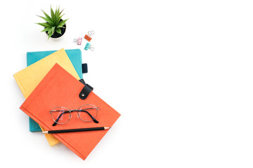 Flat lay black to school and education concept on white table desk with stack of book and pencil, green plant and supplies, Top view with copy space, work space
