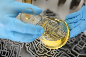 Male hands in protective gloves hold test tube