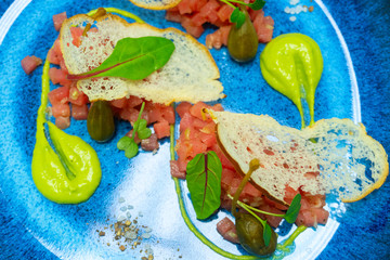 tuna Tartar with avocado sauce, capers, lettuce and croutons