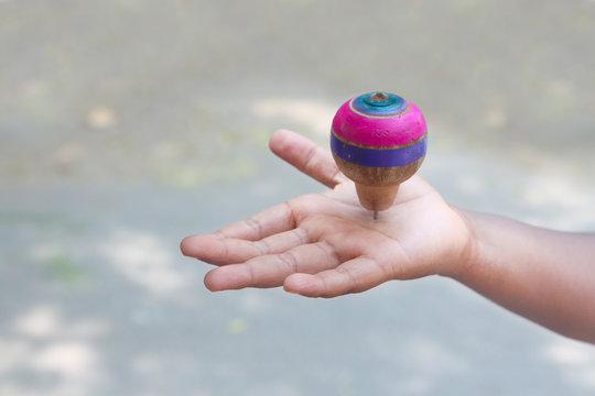  Classic wooden spinning top toy over the palm