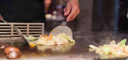 Japanese chef cooking meat in teppanyaki restaurant