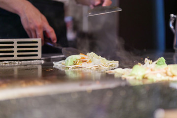 Japanese chef cooking meat in teppanyaki restaurant