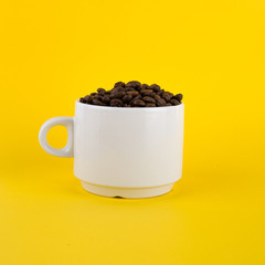 cup of coffee with coffee beans on yellow background