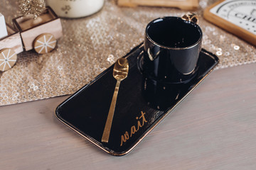 Top view of black coffee mug near wooden cutting board for cheese. Copy space
