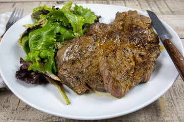 grilled prime rib and salad on a plate