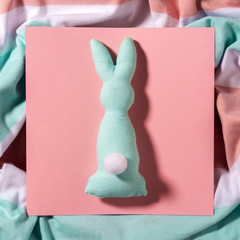 Easter card with a rabbit soft toy made of fabric, on a pink square card of paper