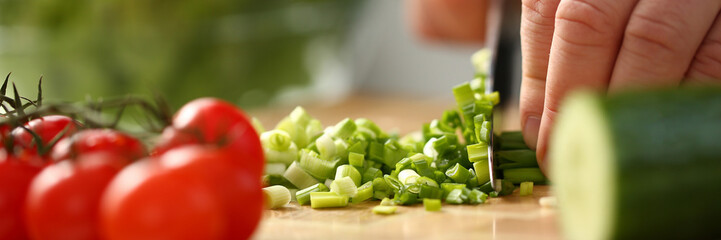 Cook holds knife in hand and cuts on