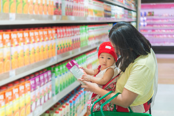 Mother and baby shopping in the supermarket,Thai woman has a daugther