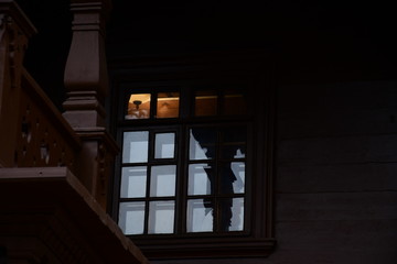 Drown wooden window. light through a wooden window. wall lamp on the wall.